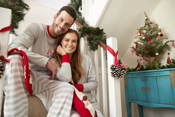 クリスマスの朝に階段の上に座ってのパジャマを着てカップルの肖像画 — ストック写真