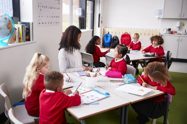 Giovane Insegnante Scuola Infantile Seduta Tavolo Una Classe Con Suoi — Foto Stock