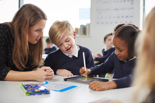 Lehrerin Hilft Zwei Kindern Mit Einem Tablet Computer Schreibtisch Einem — Stockfoto