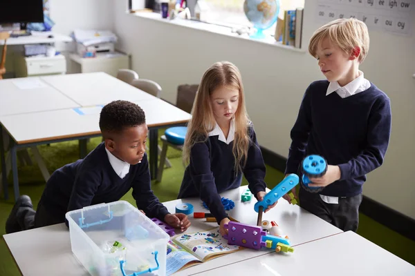 Verhoogde Weergave Van Drie Basisschoolkinderen Aan Een Tafel Een Klaslokaal — Stockfoto