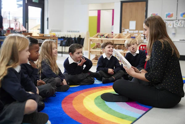 Niños Escuela Primaria Sentados Suelo Clase Escuchando Maestra Leyendo Libro —  Fotos de Stock