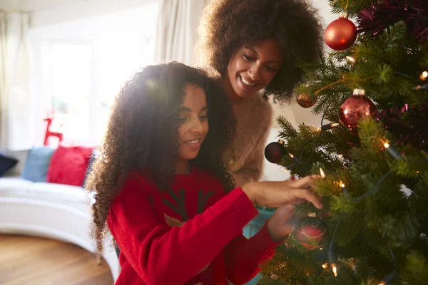 母亲和女儿挂在圣诞树上的装饰在家 — 图库照片