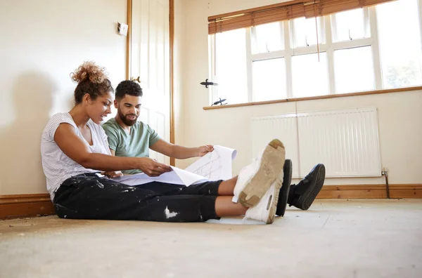 Paar Zittend Vloer Plannen Lege Ruimte Van Nieuwe Huis Kijken — Stockfoto