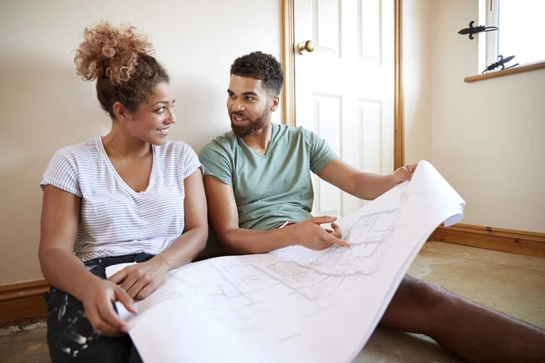 Paar Zittend Vloer Plannen Lege Ruimte Van Nieuwe Huis Kijken — Stockfoto