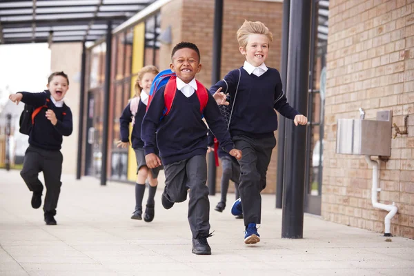 Счастливые Школьники Одетые Школьную Форму Рюкзаки Бегущие Дорожке Перед Школьным — стоковое фото