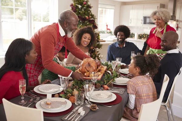 Großvater Bringt Truthahnbraten Bei Einer Mehrgenerationen Familienweihnachtsfeier Auf Den Tisch — Stockfoto