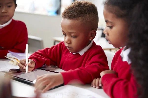 Tres Niños Escuela Kindergarten Sentados Escritorio Aula Usando Una Tableta —  Fotos de Stock