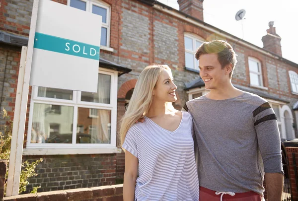 Pareja Emocionada Pie Fuera Nueva Casa Con Signo Vendido —  Fotos de Stock