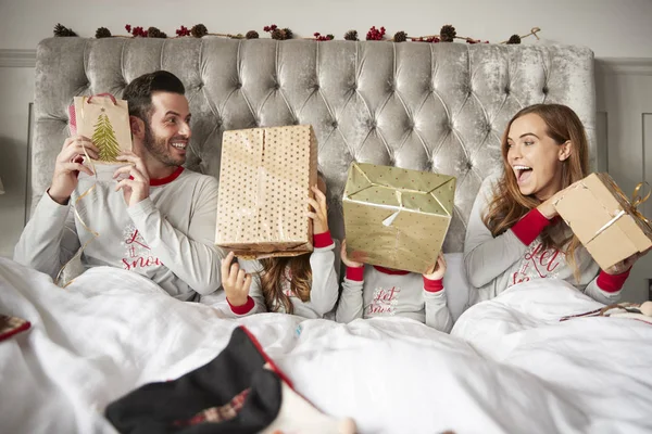 Emocionada Familia Cama Casa Sacudiendo Cajas Regalo Día Navidad — Foto de Stock