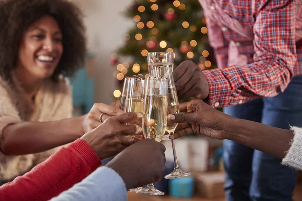 Close Up Of Friends Making A Toast With Champagne As They Celebrating Christmas At Home Together