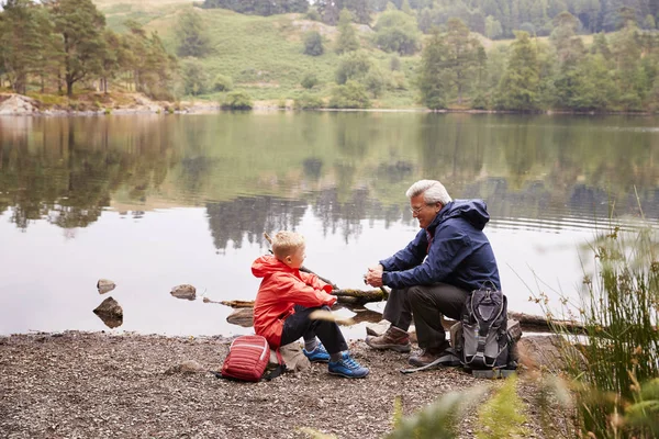 Grand Père Petit Fils Assis Bord Lac Parlant Vue Surélevée — Photo