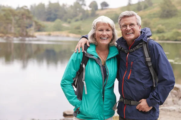 Gelukkige Senior Paar Staande Oever Van Een Meer Glimlachen Naar — Stockfoto