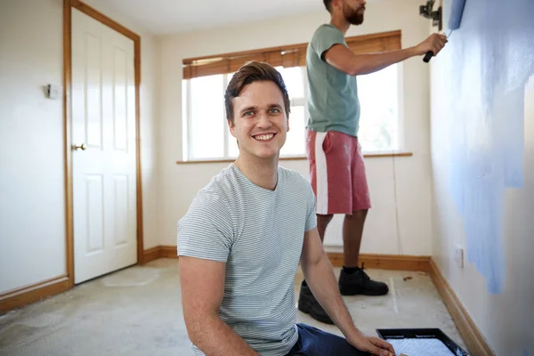 新しい家の部屋を飾る 一緒に壁を塗る つの男性の肖像画 — ストック写真