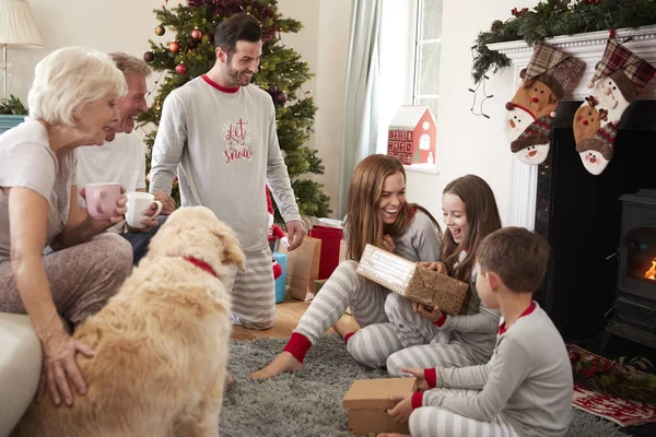 世代家族でホーム開幕ギフト ラウンジでクリスマスの日にパジャマを着て — ストック写真