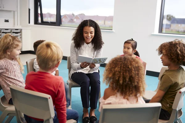 Ung Kvinnlig Skollärare Läsa Bok Till Dagisbarn Sitter Stolar Cirkel — Stockfoto