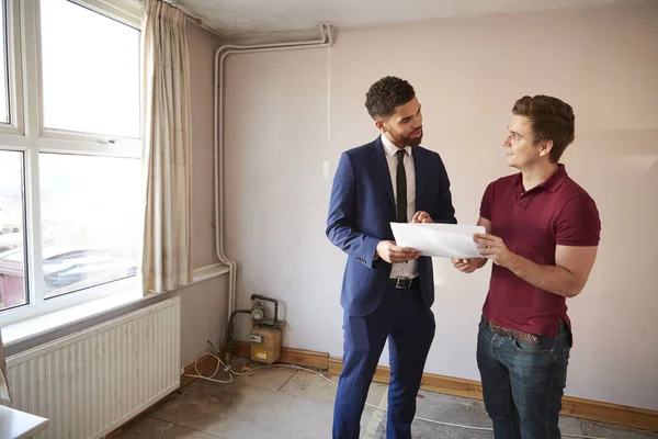 Hombre Primera Vez Comprador Mirando Casa Encuesta Con Agente Inmobiliario —  Fotos de Stock