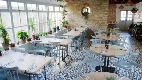 空のテーブルと窓の下枠 昼間の室内用植物でレストランの大きな窓で椅子のハンドヘルド ショット — ストック動画