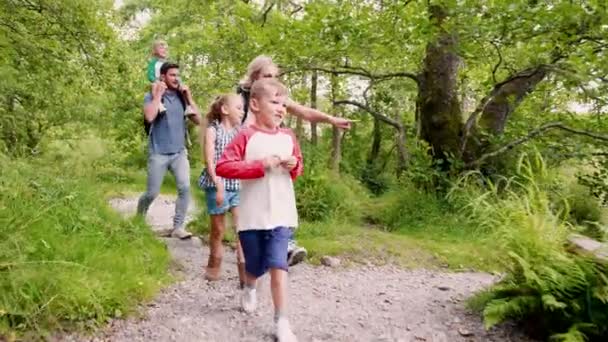英国湖地区の川沿いのパスに沿って歩く 人の子供を持つ親のスローモーション — ストック動画
