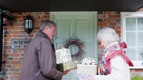 Senior Parents Carrying Gifts Greeting Adult Offsprings Front Door Arriving — Stock Video