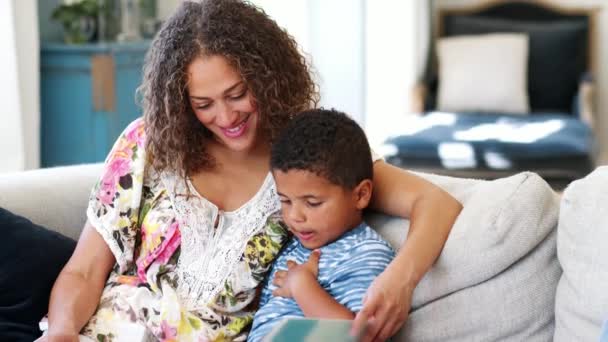 Madre Sentada Sofá Con Hijo Leyendo Libro Juntos Filmada Cámara — Vídeo de stock