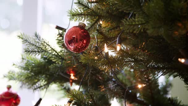 机架的焦点是挂在圣诞树上的闪闪发光的小球 带着仙灯 — 图库视频影像