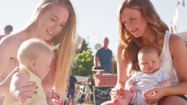 Две Матери Сидят Скамейке Играют Младенцами Английском Летнем Празднике Видео — стоковое видео