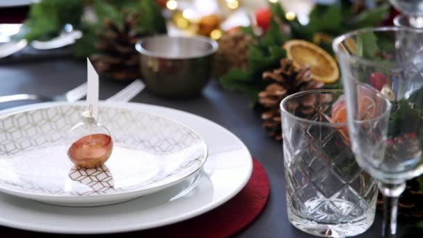 クリスマス ディナー 選択と集中のため内装のダイニング テーブルの上のプレートにクリスマスのつまらないものをすぐパン — ストック動画
