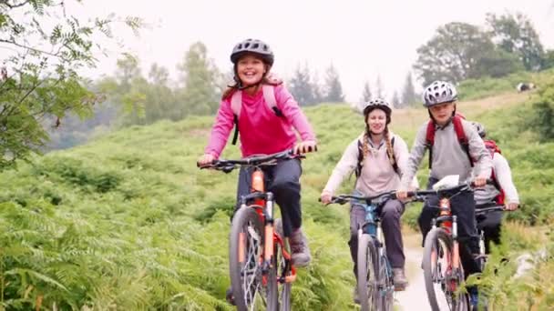両親と子供家族キャンプの休日 湖水地方 英国中に田舎のパスに乗ってマウンテン バイク — ストック動画