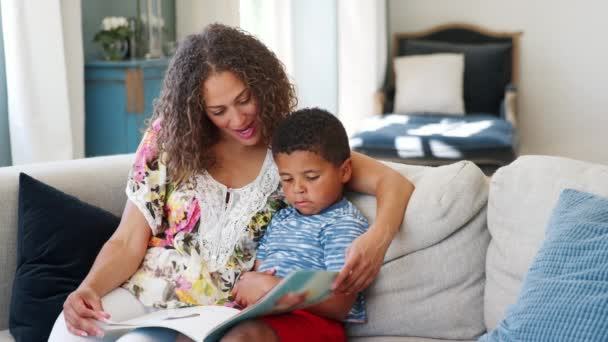 Madre Sentada Sofá Con Hijo Leyendo Libro Juntos Filmada Cámara — Vídeos de Stock