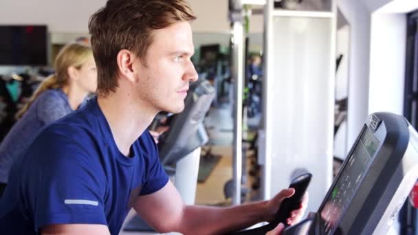 Hombre Haciendo Ejercicio Las Máquinas Ciclismo Gimnasio Video Filmado Cámara — Vídeos de Stock