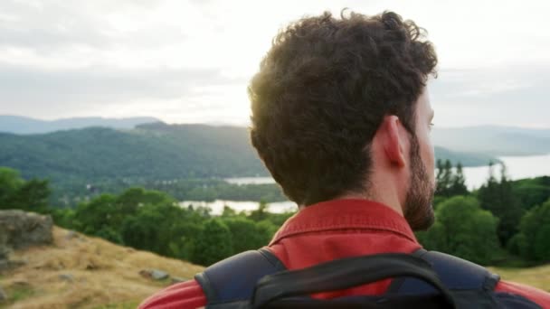 年轻的成年白种人站在山顶上欣赏山间徒步时的风景 近距离 — 图库视频影像