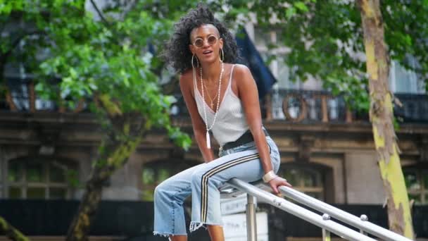 Trendy Young Black Woman Wearing Camisole Side Stripe Jeans Sitting — Stock Video