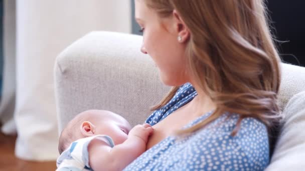 特写镜头的母亲坐在家里的小女儿坐在家里哺乳 儿子从她的肩膀上看 视频拍摄慢动作 — 图库视频影像