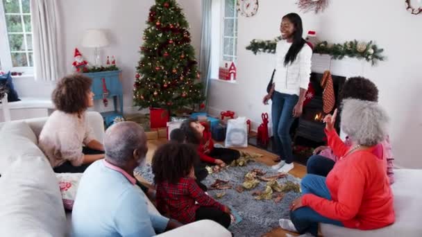 多世代家族の家で一緒にクリスマスを祝う スローモーションで撮影する収集彼らとしてジェスチャー ゲームをプレイ — ストック動画