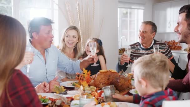 Mehrgenerationenfamilie Sitzt Tisch Und Stößt Vor Dem Erntedank Essen Aufgenommen — Stockvideo