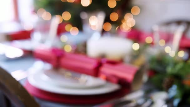 アレンジ版や季節的な装飾 選択と集中のライトとクリスマス ツリー赤クラッカーと一緒にクリスマス ディナー テーブルのラック フォーカス ショット — ストック動画