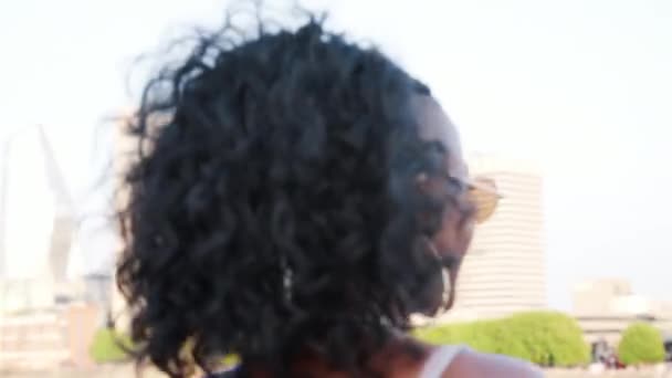 Трепетная Молодая Чернокожая Женщина Камисоле Солнцезащитных Очках Идет Мосту Оглядывается — стоковое видео