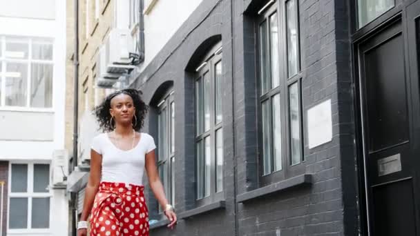 时尚的年轻黑人妇女穿着红色波尔卡点裤子走在大街上 低角度 — 图库视频影像