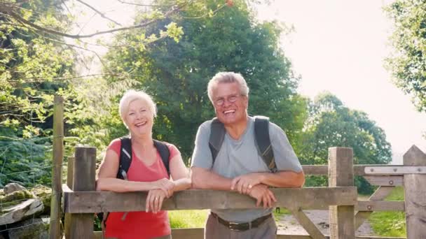 Portret Van Senior Paar Kijkt Uit Houten Poort Als Wandelen — Stockvideo