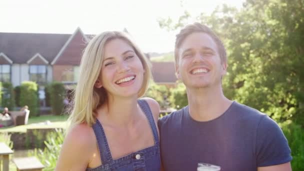 幸福微笑的夫妇享受夏季饮料在酒吧花园对燃烧的太阳的肖像 在慢动作视频拍摄 — 图库视频影像