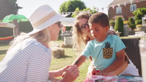 女人面对绘画男孩在英国夏天的花园盛宴 在慢动作中拍摄 — 图库视频影像