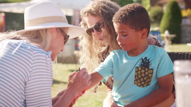 女人面对绘画男孩在英国夏天的花园盛宴 在慢动作中拍摄 — 图库视频影像