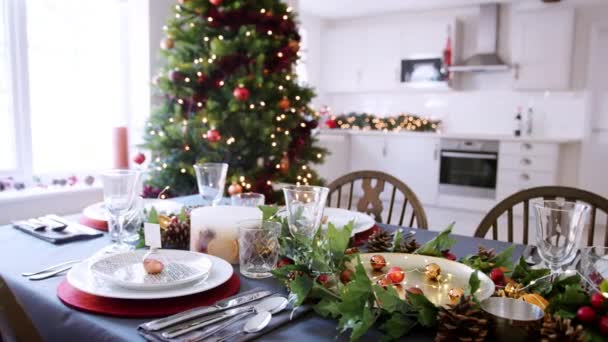 节日圣诞餐桌与小名片持有人安排在一个盘子和绿色和红色的季节性装饰 高架景观 — 图库视频影像