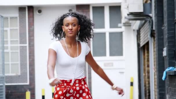 穿着红色波尔卡圆点长裤在街头跳舞的时尚年轻黑人女子 — 图库视频影像