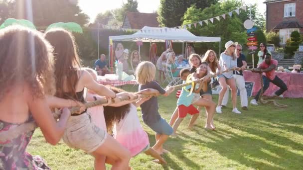 一群成人和儿童在夏天的花园盛宴上进行拔河比赛 视频以慢动作拍摄 — 图库视频影像