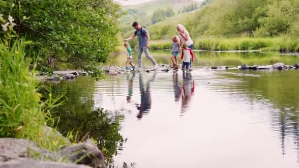 スローモーションで撮影を使用して川を横断する子供たちを助ける親の完全な長さの側面図 — ストック動画