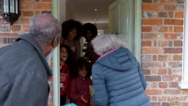 Grandparents Carrying Gifts Greeting Family Front Door Arriving Spend Christmas — Stock Video