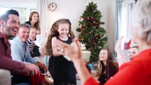 Enkelin Rennt Mit Geschenk Auf Oma Als Mehrgenerationenfamilie Gemeinsam Weihnachten — Stockvideo