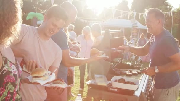 男子提供食物从烧烤摊位在夏季花园节日 视频拍摄在慢动作 — 图库视频影像