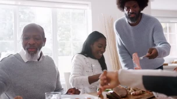 Keluarga Ras Campuran Multi Generasi Duduk Meja Saling Melayani Makan — Stok Video